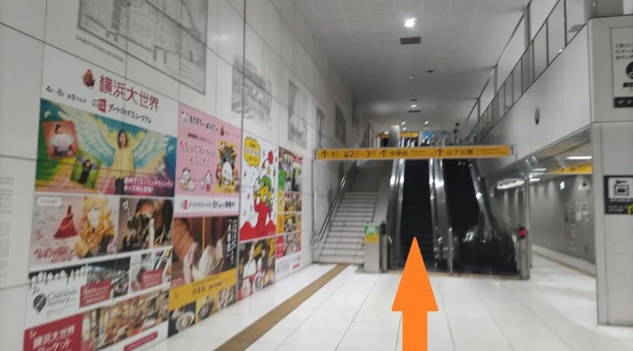 中華街・山下公園方面（1番出口）を示す黄色い案内表示と、地下1階へ上がる階段・エスカレーター