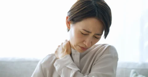 頚椎症による首の痛みで首を押さえる女性